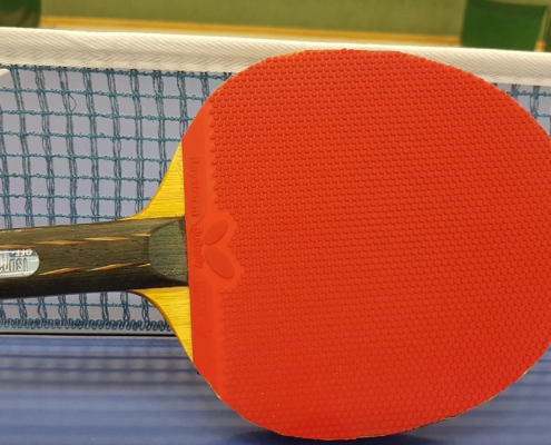 Tischtennisschläger vor Netz