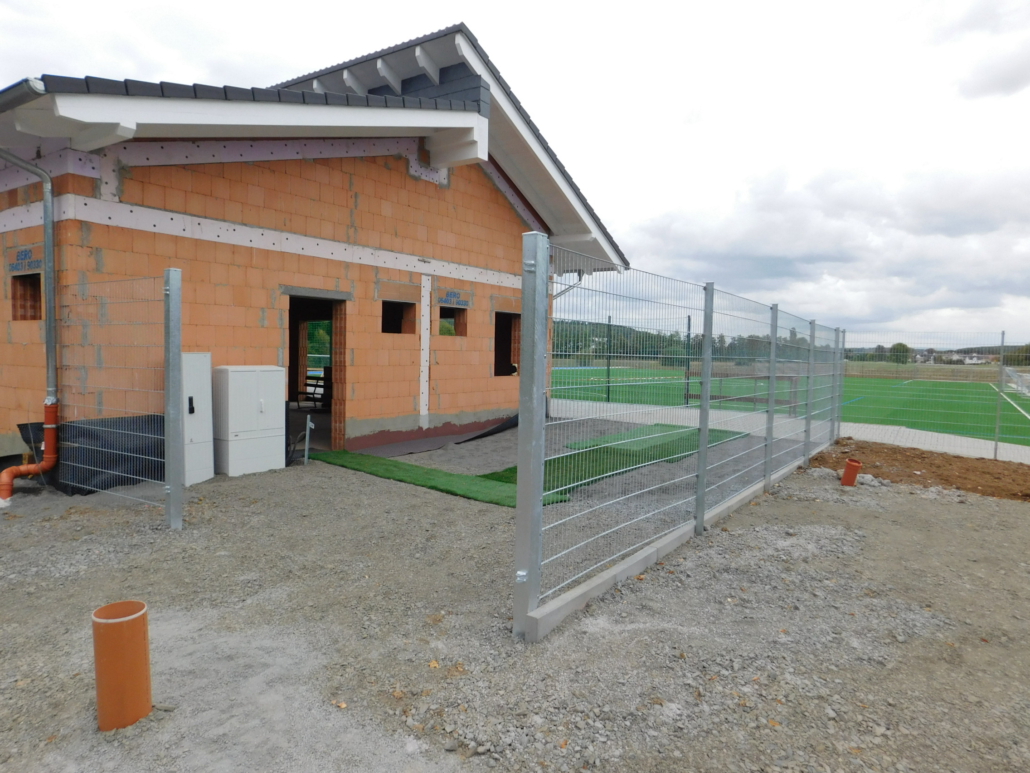 Baufortschritt Sportheim Außenansicht mit Terrasse und Kunstrasenplatz vom 22. September 2018