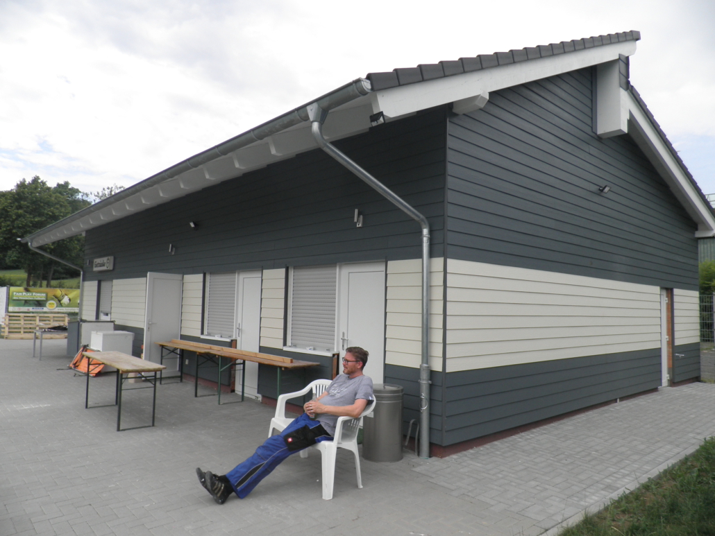 Außenansicht Sportheim mit fertiger Verkleidung und Eingangsbereich und Terrasse vom 27. Juni 2020