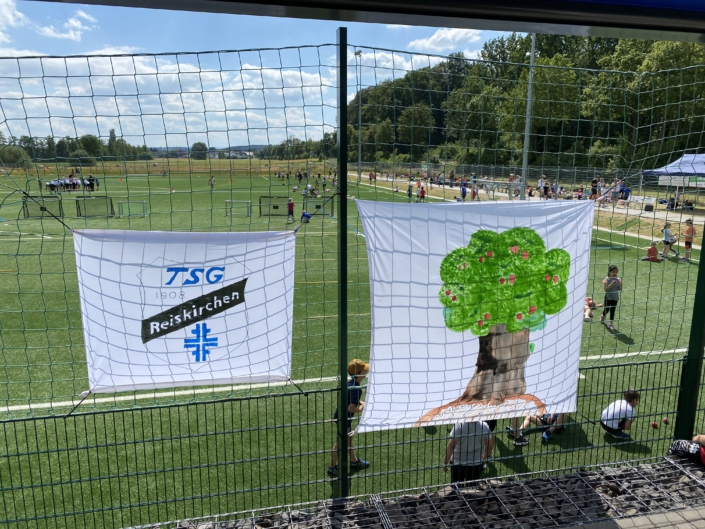 Aufnahme zu den Bundesjugendspielen: Sie zeigt die Fahnen mit Logos der TSG und der Kirschbergschule.